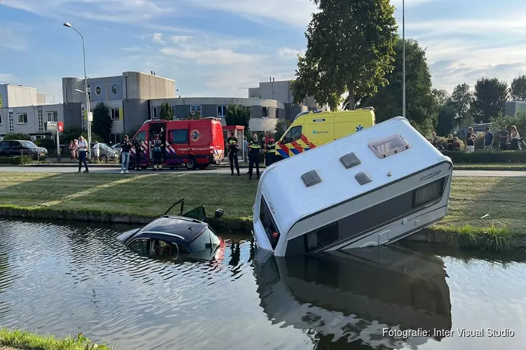 Auto met caravan te water in Velserbroek